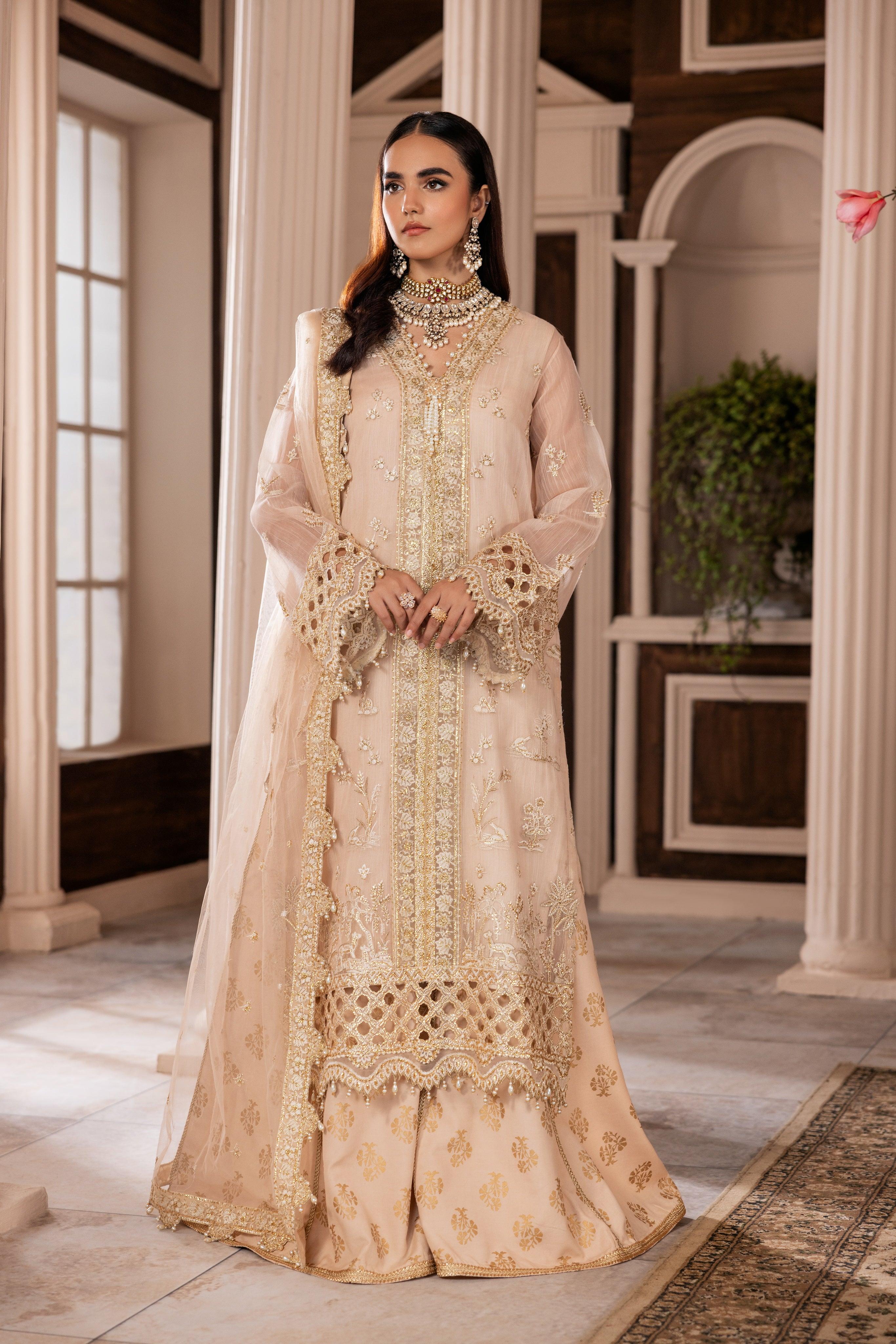 Woman in elegant embroidered beige formal dress from LA ELISE, indoor classic setting