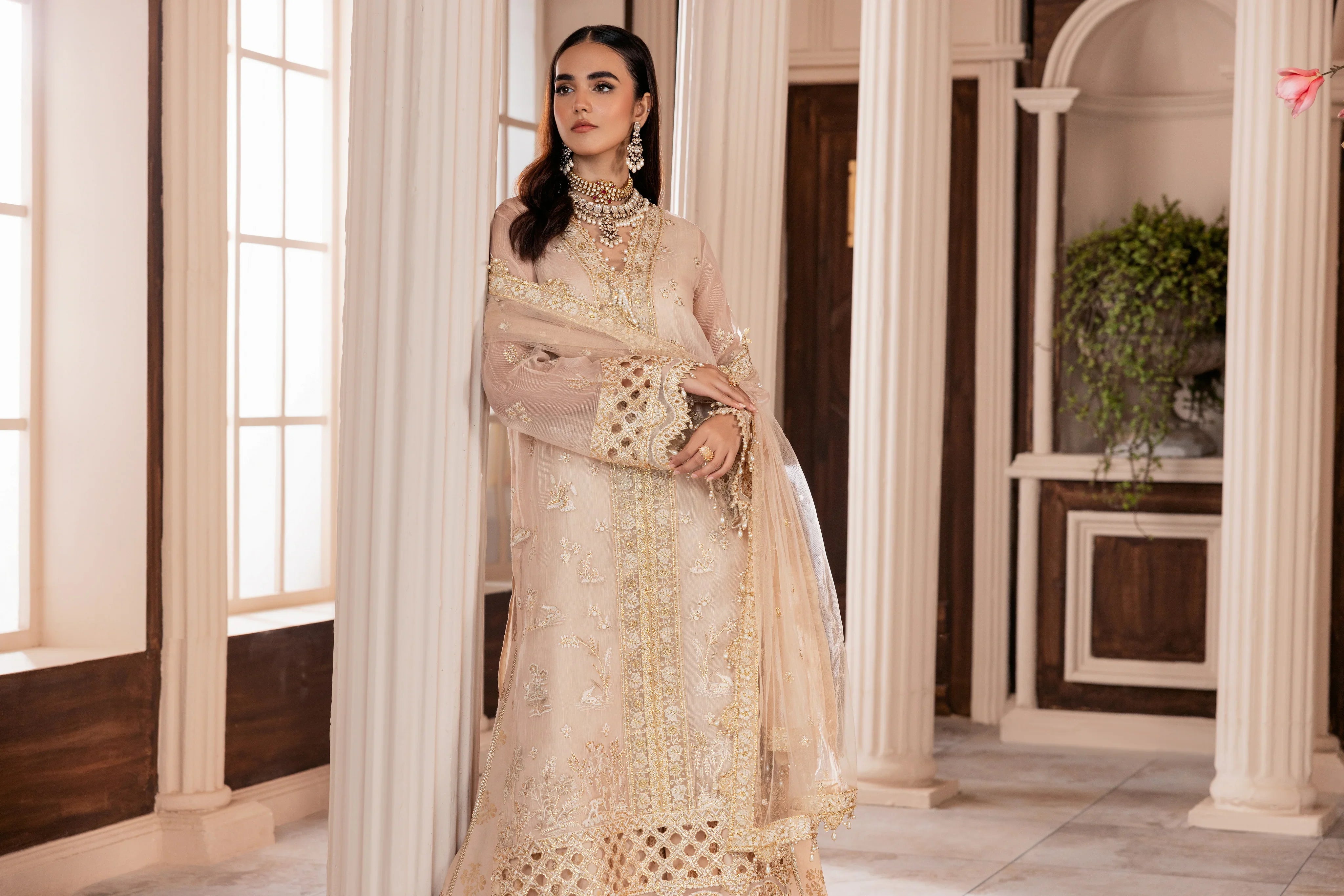 Woman in elegant beige embroidered formal dress, LA ELISE unstitched collection, classic interior