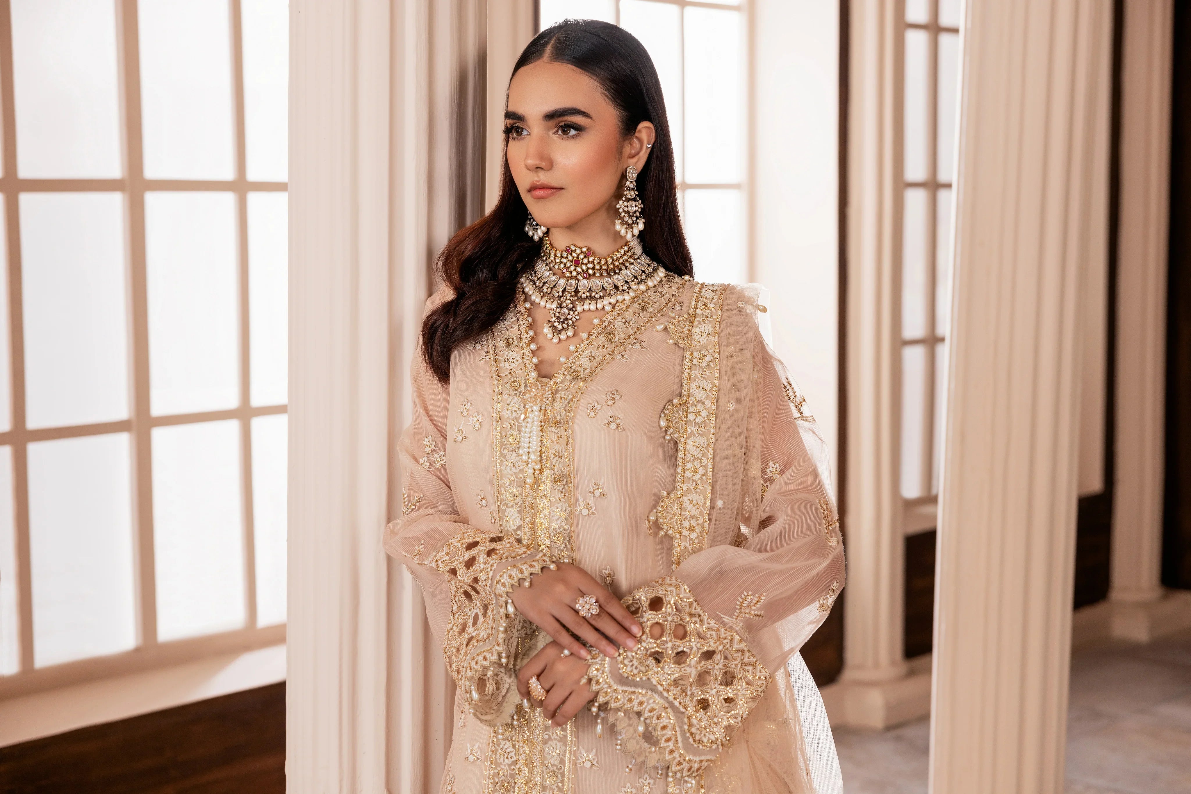 Woman wearing an embellished beige formal dress with gold embroidery, LA ELISE fashion