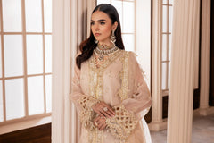 Woman wearing an embellished beige formal dress with gold embroidery, LA ELISE fashion
