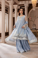 Woman in elegant blue embroidered formal dress from LA ELISE, posing in a classic interior