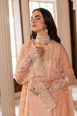 Woman in peach embroidered formal dress with pearl jewelry, LA ELISE women's fashion