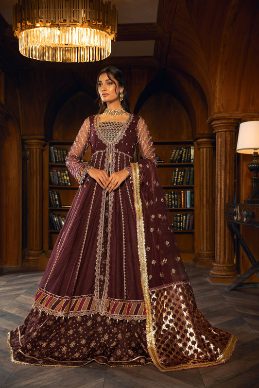 Woman in maroon embellished formal dress by LA ELISE, standing in elegant library.