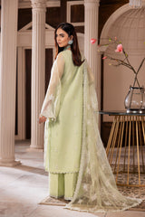 Woman in pastel green embroidered formal dress, standing indoors at LA ELISE fashion store