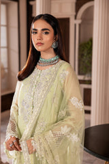 Woman wearing pastel green embroidered formal dress with statement jewelry, LA ELISE fashion