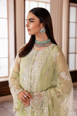 Woman in light green embroidered formal dress and statement jewelry, LA ELISE fashion