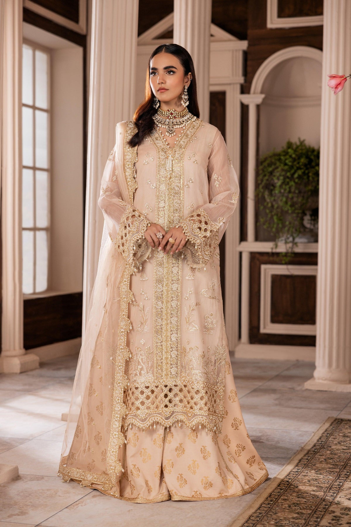 Woman in elegant embroidered beige formal dress from LA ELISE, indoor classic setting