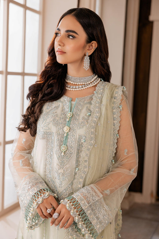 Woman in embroidered pastel formal dress with statement jewelry, LA ELISE fashion, indoor setting