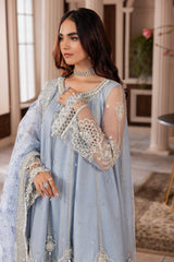 Woman in light blue embroidered formal dress from LA ELISE, styled with pearl jewelry