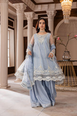Woman in elegant light blue embroidered formal dress at LA ELISE, classic interior backdrop