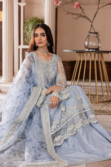 Woman in elegant blue embroidered formal dress from LA ELISE, seated in a chic interior.