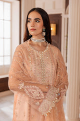 Woman in peach embroidered formal dress with pearl jewelry, LA ELISE women’s fashion