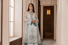 Woman in pastel embroidered formal dress by LA ELISE, standing in elegant hallway