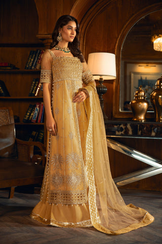 Woman in gold embroidered formal dress from LA ELISE, posing indoors with elegant decor