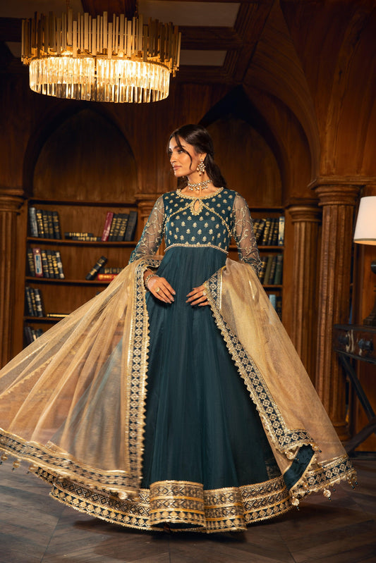 Woman wearing an elegant teal and gold formal dress from LA ELISE in a luxury library