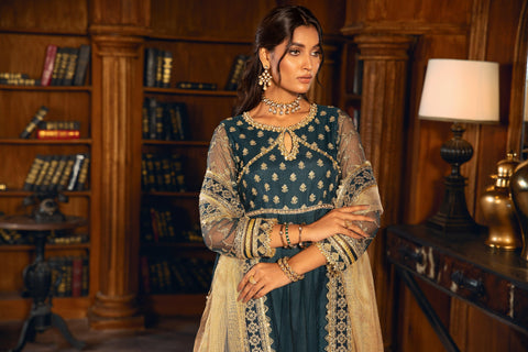 Woman in teal and gold embroidered formal dress from LA ELISE, posing in elegant library