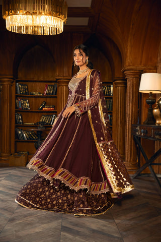 Woman in maroon embroidered formal dress by LA ELISE, elegant setting with chandelier