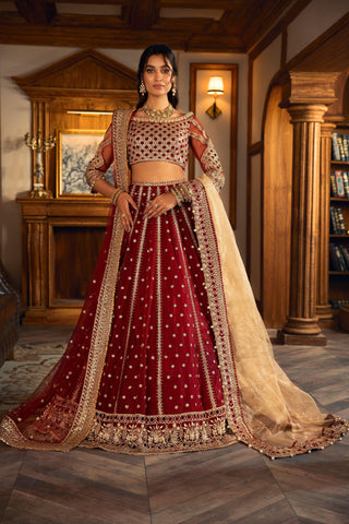 Woman modeling maroon and gold embroidered formal lehenga outfit by LA ELISE in elegant room