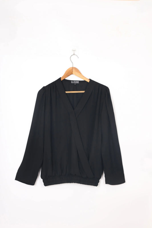 LA ELISE black women's wrap blouse with long sleeves on hanger, minimalist background